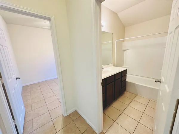 a bathroom with a bathtub shower sink vanity and mirror