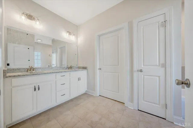 a spacious bathroom with a granite countertop sink and mirror