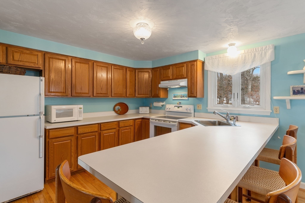 37 Ansel Howland Road Barnstable, MA 02632 - Photo 8 of 26 a kitchen with a table chairs refrigerator and cabinets