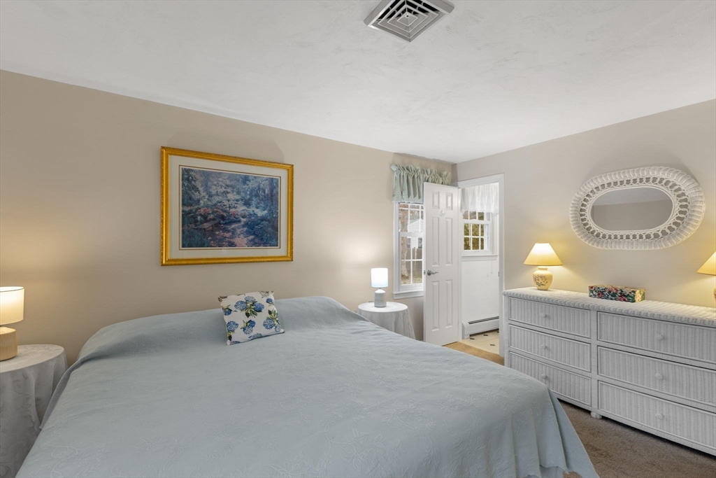 37 Ansel Howland Road Barnstable, MA 02632 - Photo 10 of 26 a bedroom with a bed and a chandelier