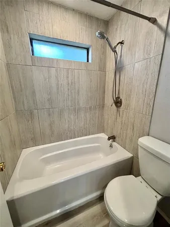 a bathroom with a white toilet and a bathtub