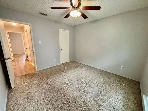 an empty room with a ceiling fan and a bathroom