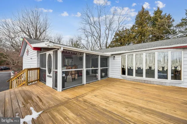 a view of a house with a large window and wooden fence
