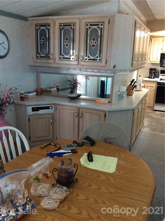 306 Mallard Loop Waynesville, NC 28785 - Photo 12 of 19 a view of a kitchen with kitchen island a stove a sink a chimney and wooden floor