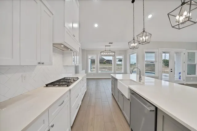 a large kitchen with kitchen island lots of counter space wooden floor and stainless steel appliances