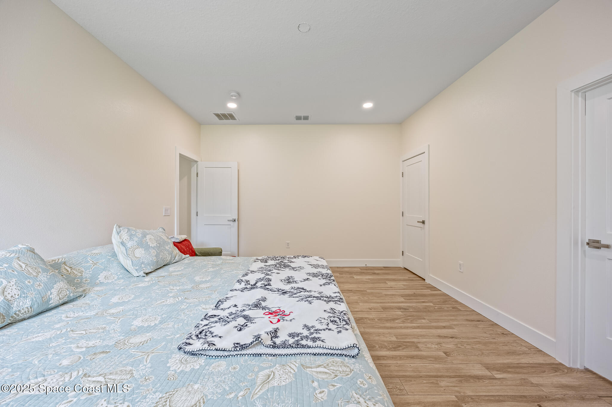 1405 Highland Court Cocoa, FL 32922 - Photo 13 of 29 a bedroom with a large bed and a wooden floor
