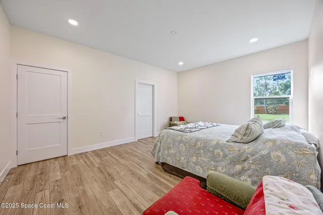 a bedroom with a bed and wooden floor