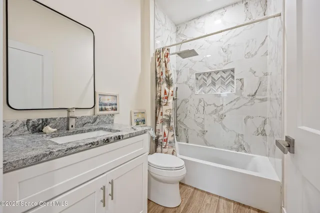 a bathroom with a granite countertop sink a toilet and a bathtub
