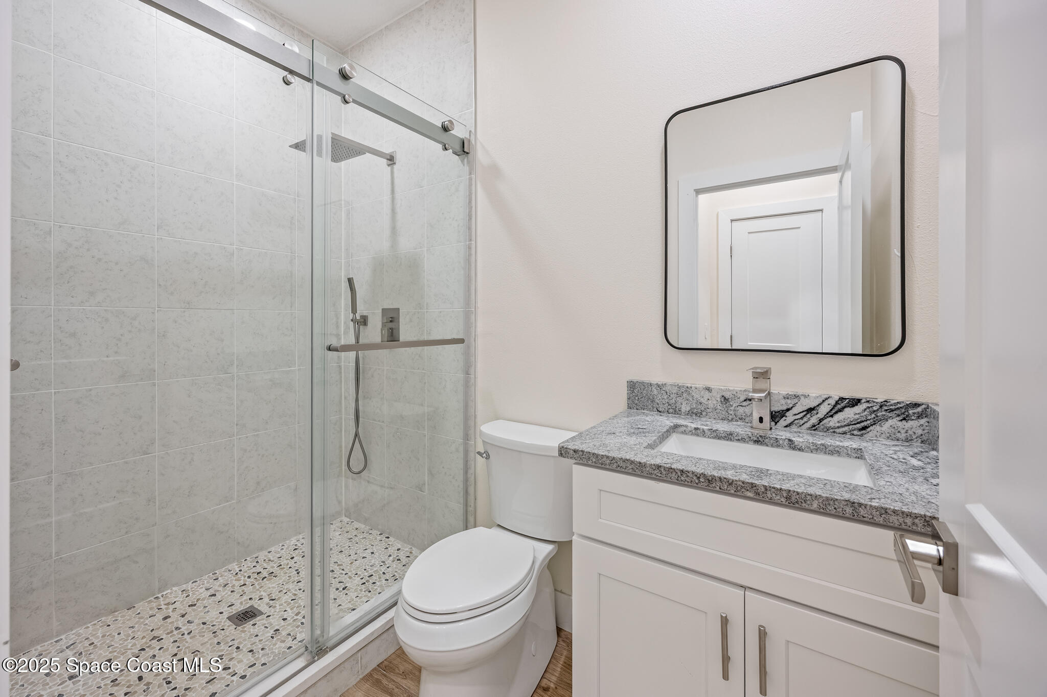1405 Highland Court Cocoa, FL 32922 - Photo 23 of 29 a bathroom with a granite countertop sink toilet mirror and shower