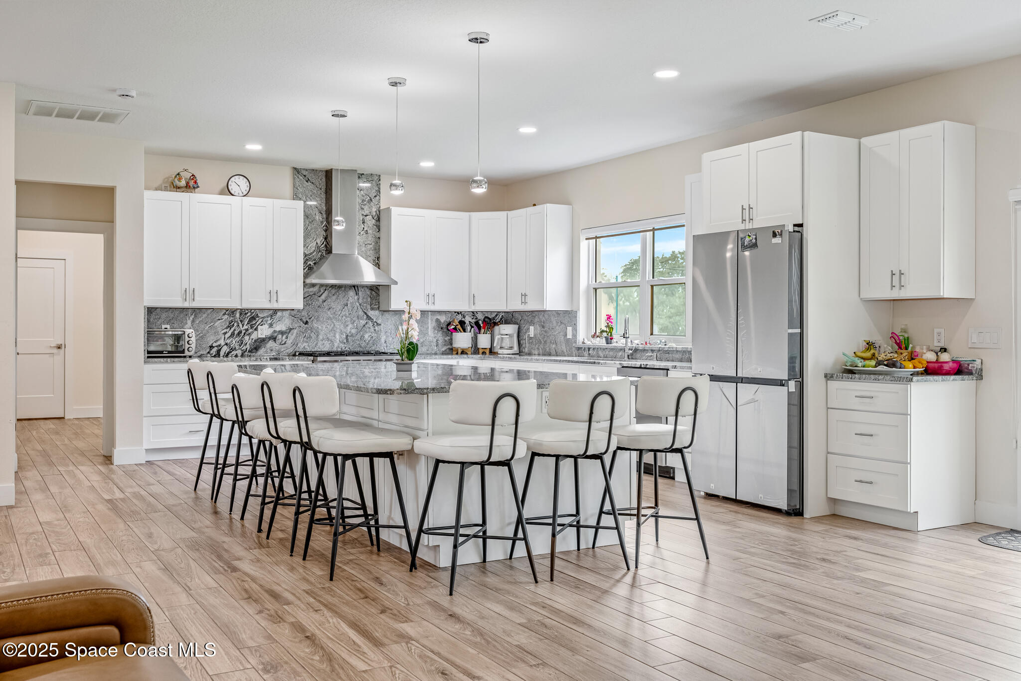 1405 Highland Court Cocoa, FL 32922 - Photo 5 of 29 a kitchen with stainless steel appliances granite countertop a stove a refrigerator a microwave a sink and white cabinets with wooden floor