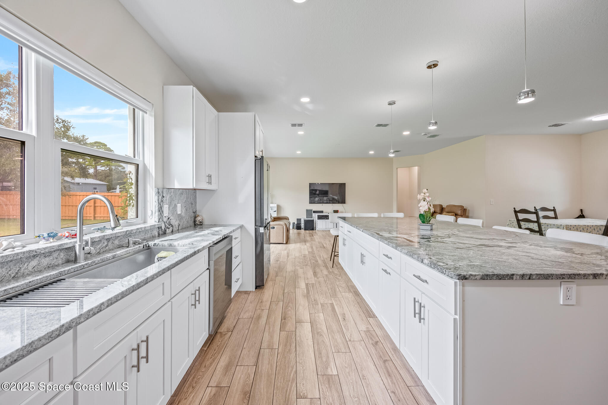 1405 Highland Court Cocoa, FL 32922 - Photo 7 of 29 a large kitchen with stainless steel appliances granite countertop a lot of counter space and wooden floors
