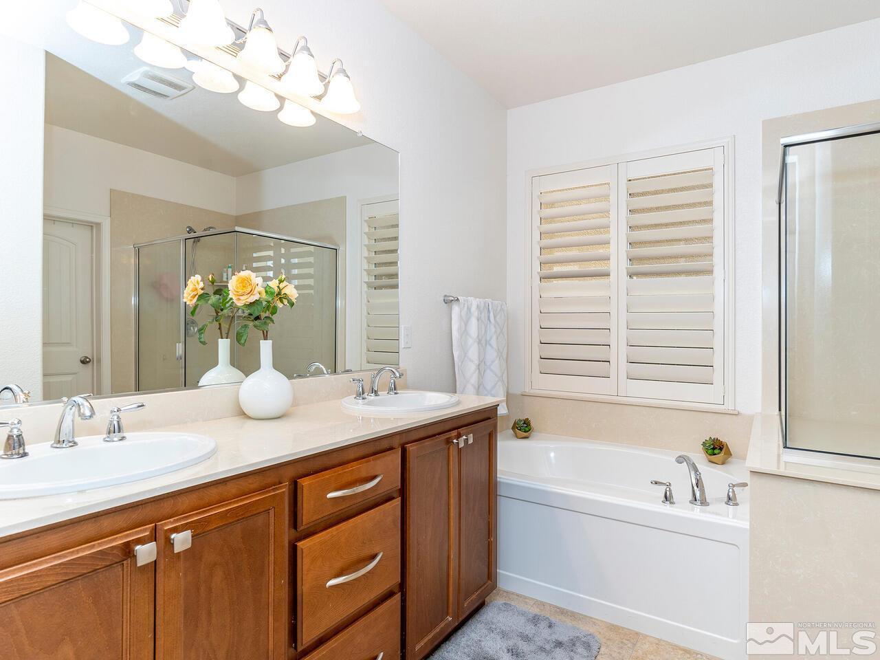 1925 Horse Prairie Road Reno, NV 89521 - Photo 15 of 32 a bathroom with a granite countertop sink a large mirror a bathtub and next to a window