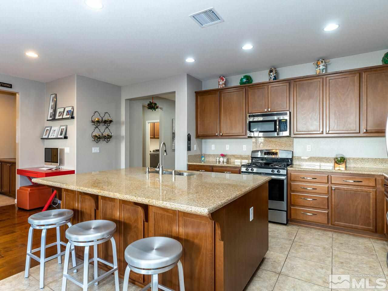 1925 Horse Prairie Road Reno, NV 89521 - Photo 4 of 32 a kitchen with stainless steel appliances granite countertop a table chairs sink and cabinets