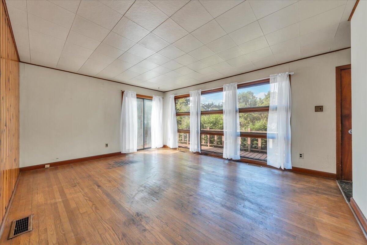 201 Long Avenue Covington, VA 24426 - Photo 6 of 43 an empty room with wooden floor and windows
