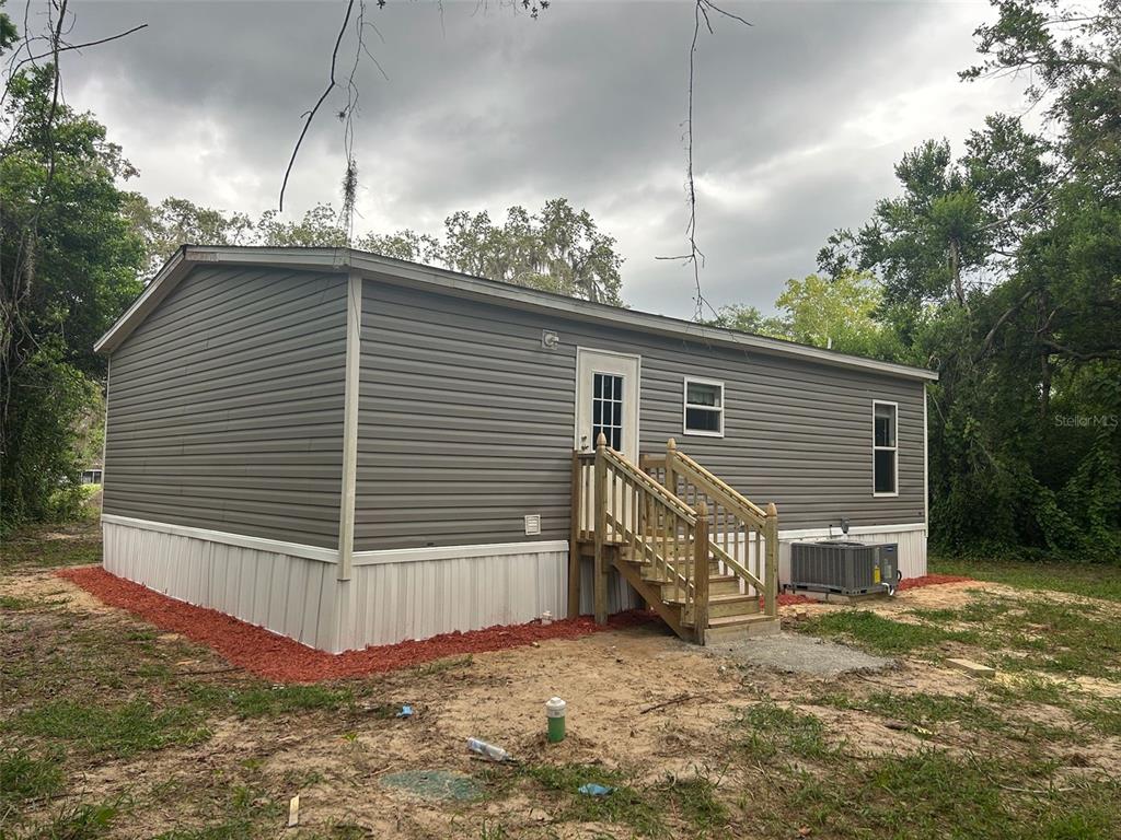 a view of house with backyard and trees