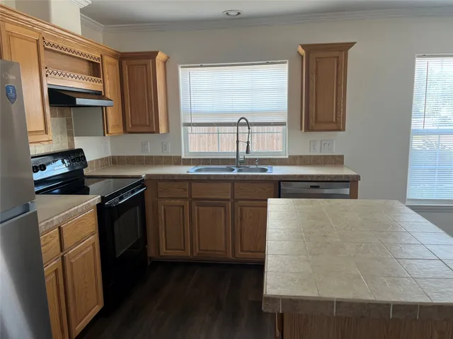 a kitchen with stainless steel appliances granite countertop a sink a stove and a microwave