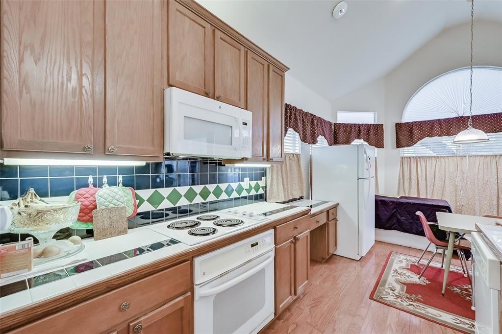 5701 Christy Lane Haltom City, TX 76137 - Photo 6 of 15 a kitchen with stainless steel appliances a sink a stove and a wooden cabinets