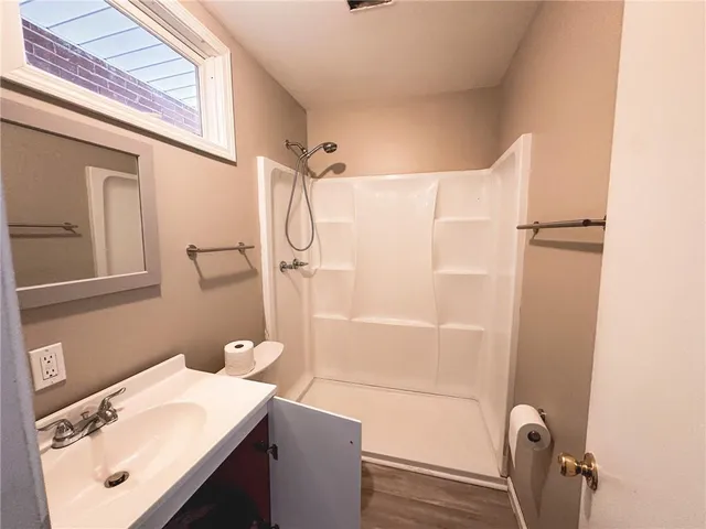 a bathroom with a sink a toilet and shower