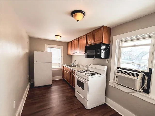 a kitchen with a refrigerator stove and wooden floor