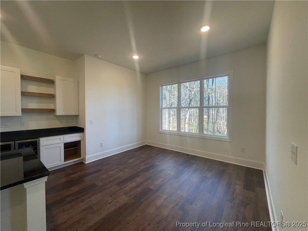 484 Falling Water Road Spring Lake, NC 28390 - Photo 5 of 18 an empty room with wooden floor cabinet and windows