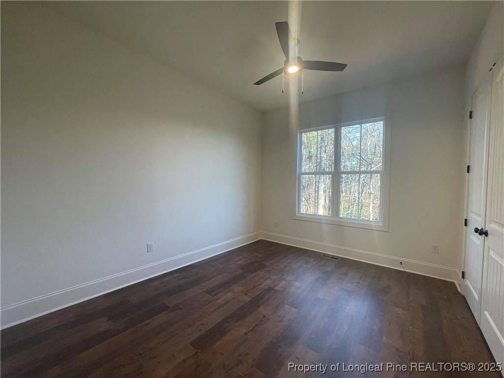 484 Falling Water Road Spring Lake, NC 28390 - Photo 9 of 18 an empty room with wooden floor chandelier fan and windows