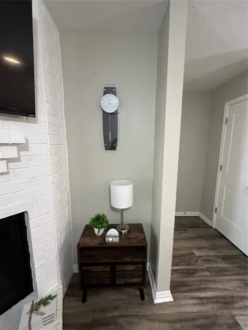 a view of a livingroom with wooden floor and a fireplace