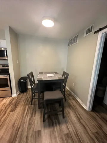 a view of a dining room with furniture and wooden floor