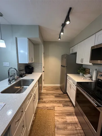 a kitchen with sink stove and refrigerator