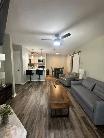 a living room with furniture and a wooden floor