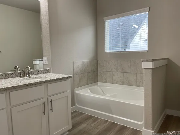 a white bath tub sitting next to a bathroom sink