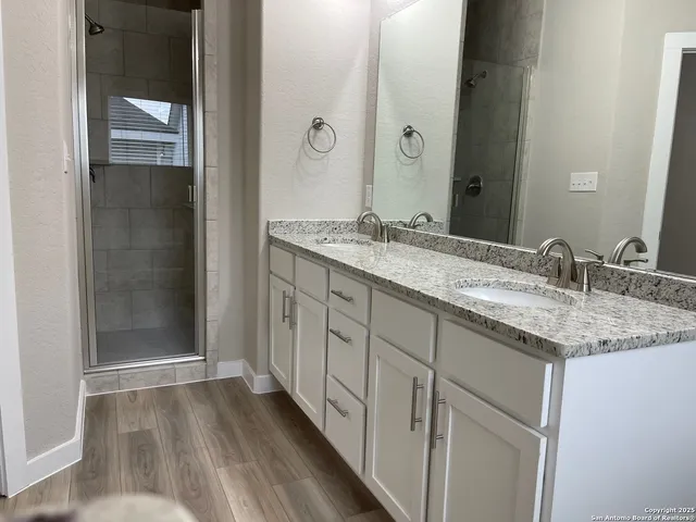 a bathroom with a granite countertop sink and a mirror