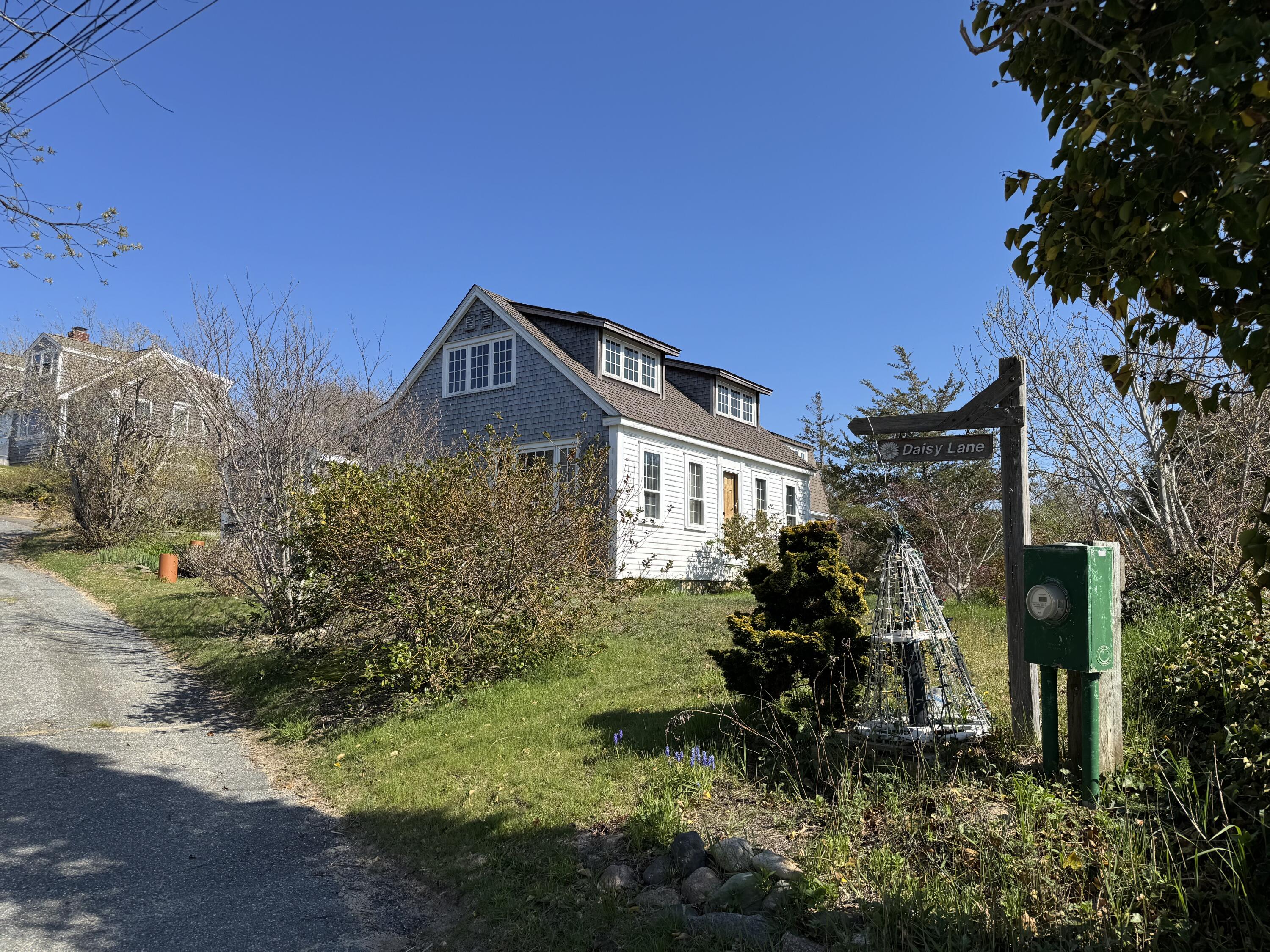 10 Benson Road Truro, MA 02666 - Photo 3 of 36 a view of a house with a small yard and a large tree