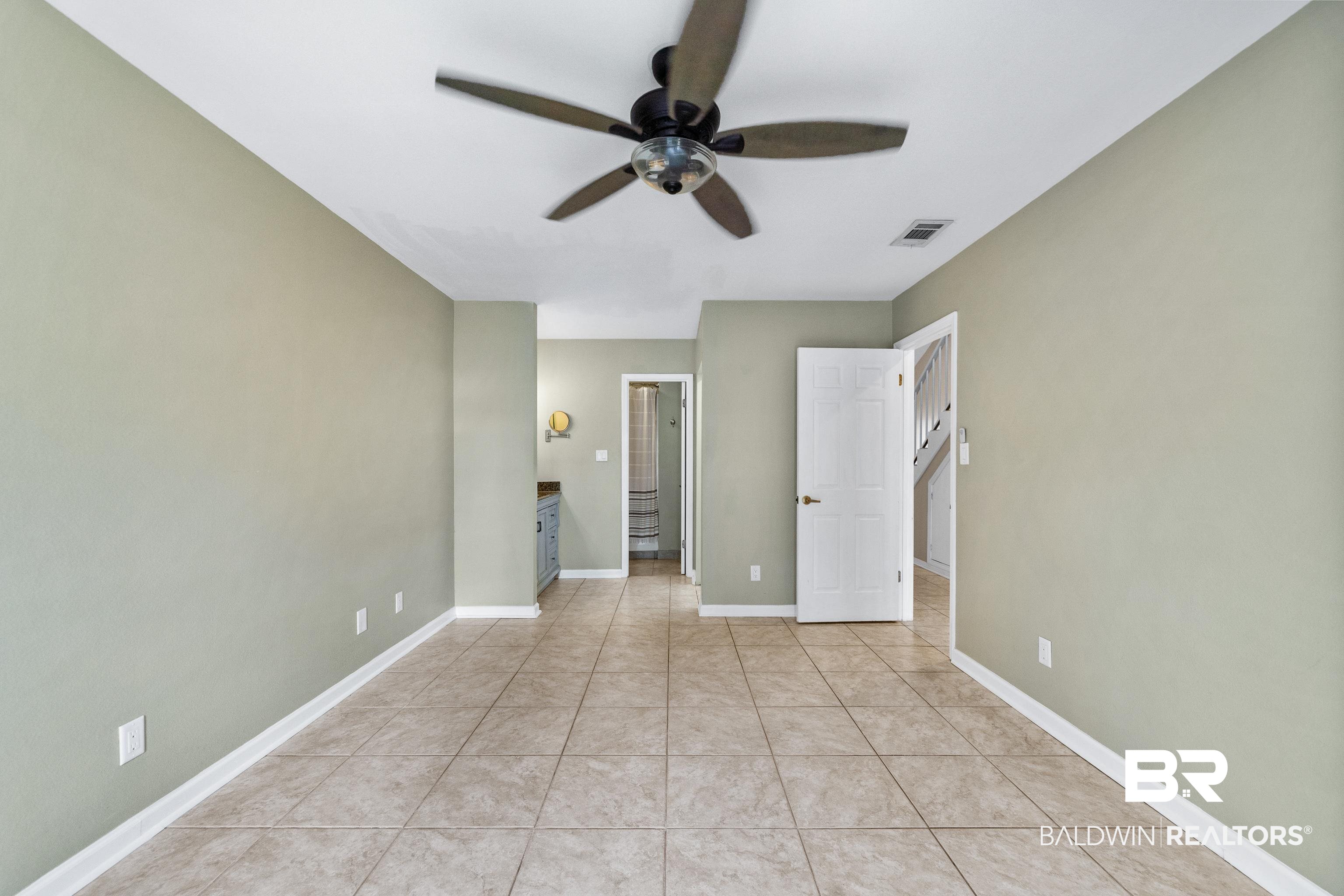 1701 Regency Road, Unit 111 Gulf Shores, AL 36542 - Photo 15 of 29 Unfurnished bedroom with ceiling fan and light tile patterned floors