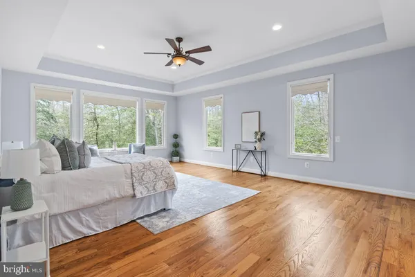 a room with wooden floor pool table and windows