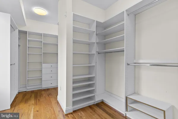 a kitchen with stainless steel appliances granite countertop a refrigerator a stove top oven a sink dishwasher and wooden cabinets with wooden floor