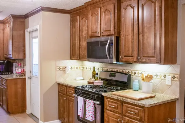 a kitchen with stainless steel appliances granite countertop a refrigerator a sink and wooden cabinets