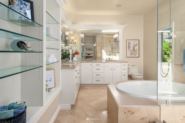 a bathroom with a granite countertop sink a mirror and shower