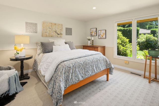 a bed sitting in a bedroom next to a window