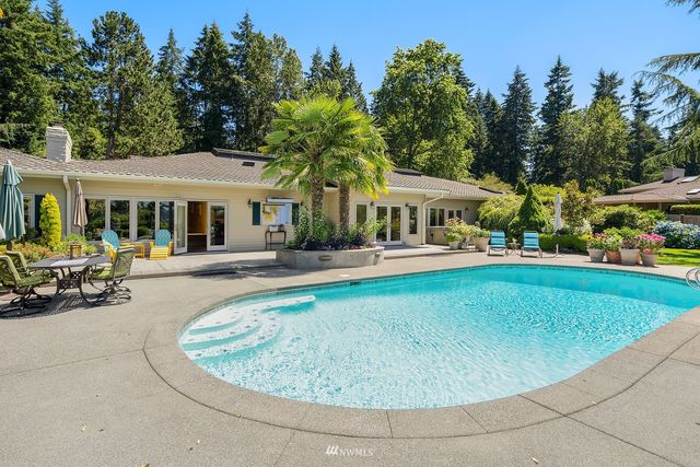 a view of a house with swimming pool and sitting area