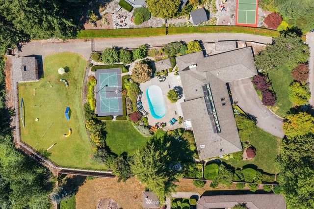 an aerial view of a house with a swimming pool a yard and a garden