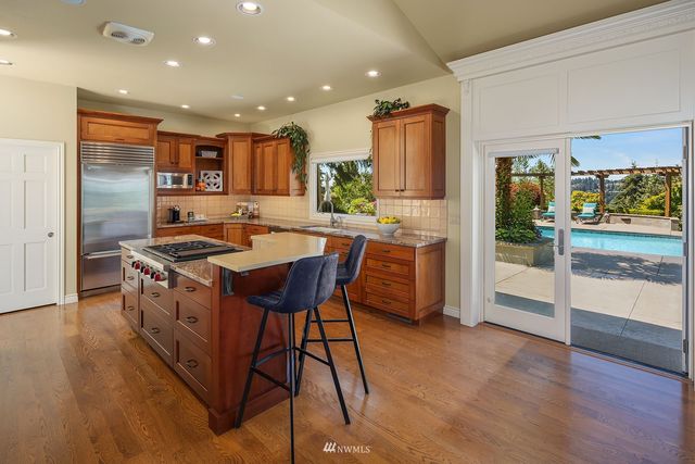 a kitchen with stainless steel appliances granite countertop a sink counter space and wooden floor