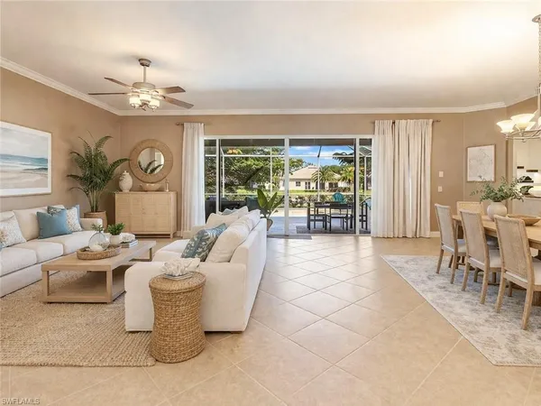 a living room with patio furniture and a large window