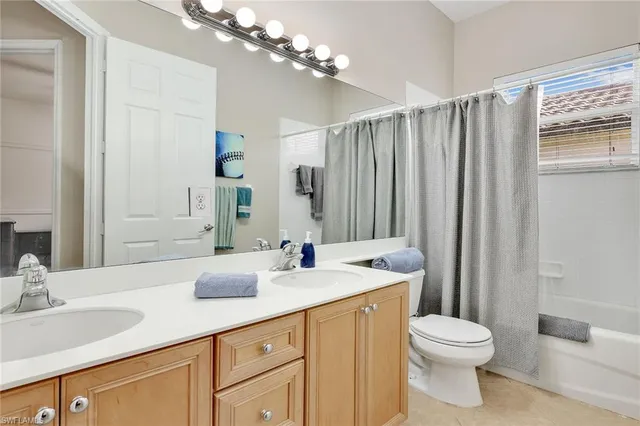 a bathroom with a double vanity sink toilet and a mirror