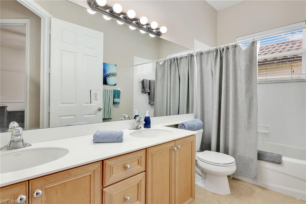 14611 Indigo Lakes Circle Naples, FL 34119 - Photo 27 of 31 a bathroom with a double vanity sink toilet and a mirror