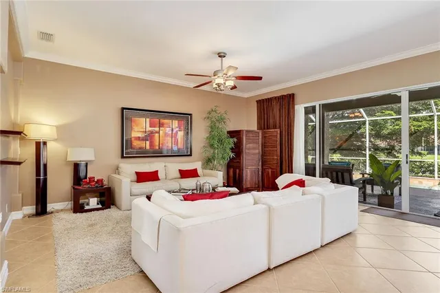 a bedroom with a bed large window and a chandelier