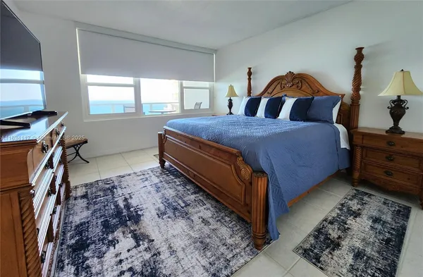a bedroom with a bed and large windows