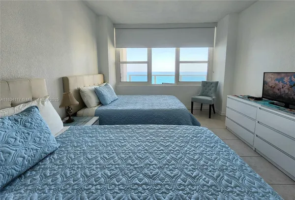 a large bedroom with a bed and wooden floor