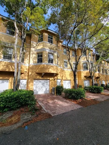 a front view of a building with streets and trees