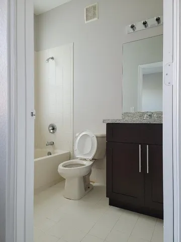 a bathroom with a granite countertop toilet a sink and bathtub