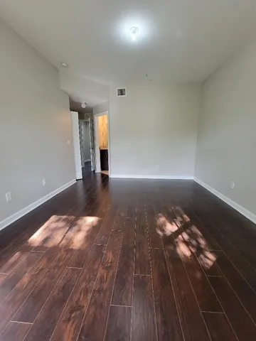 a view of empty room with wooden floor